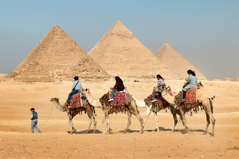 Egypt pyramids and group of people riding camels - Ask your homeschool students what they think it would be like to ride on a camel. Try having them build pyramids out of sugar cubes as an Egypt unit activity. 