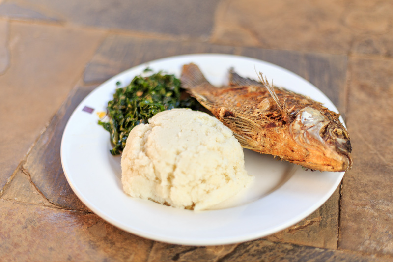 Kenyan ugali, sukuma wiki, and fish