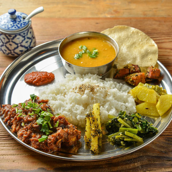 Nepalese Dal bhat plate with rice, dal, curry, and accompaniments - Kids learn about food in Nepal